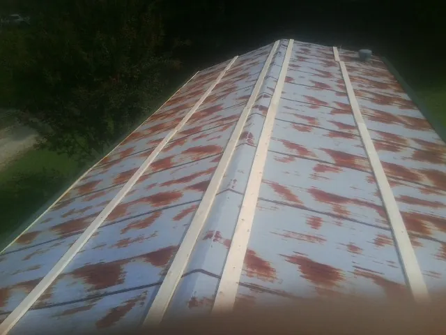 Rusted metal roof panels with new wood purlins before replacement — Storm Damage Roof Repair in Lapeer by Roofing Brothers