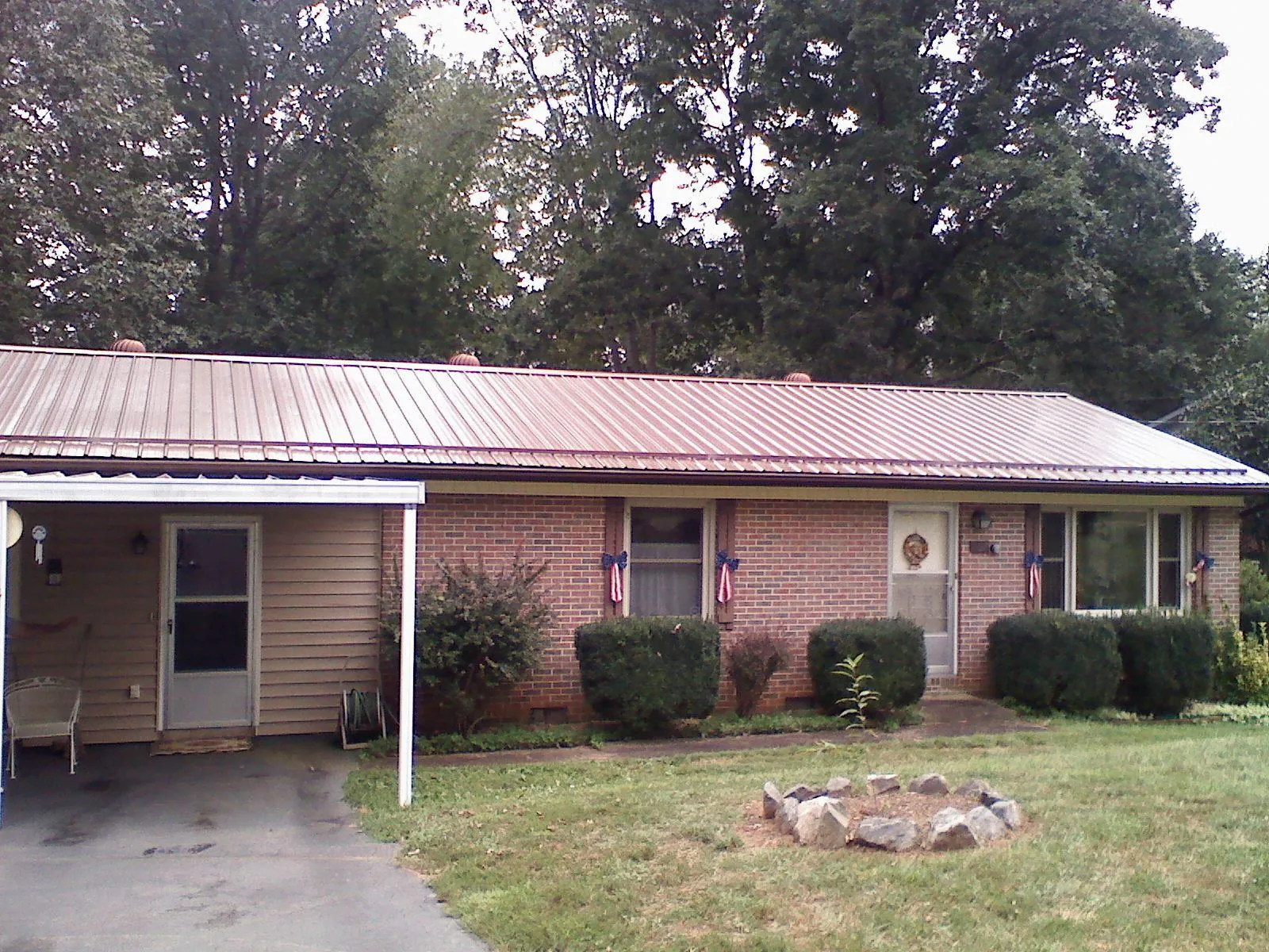 Bronze metal roof and carport on a brick ranch home — Roof Repair work by our crew in Lapeer