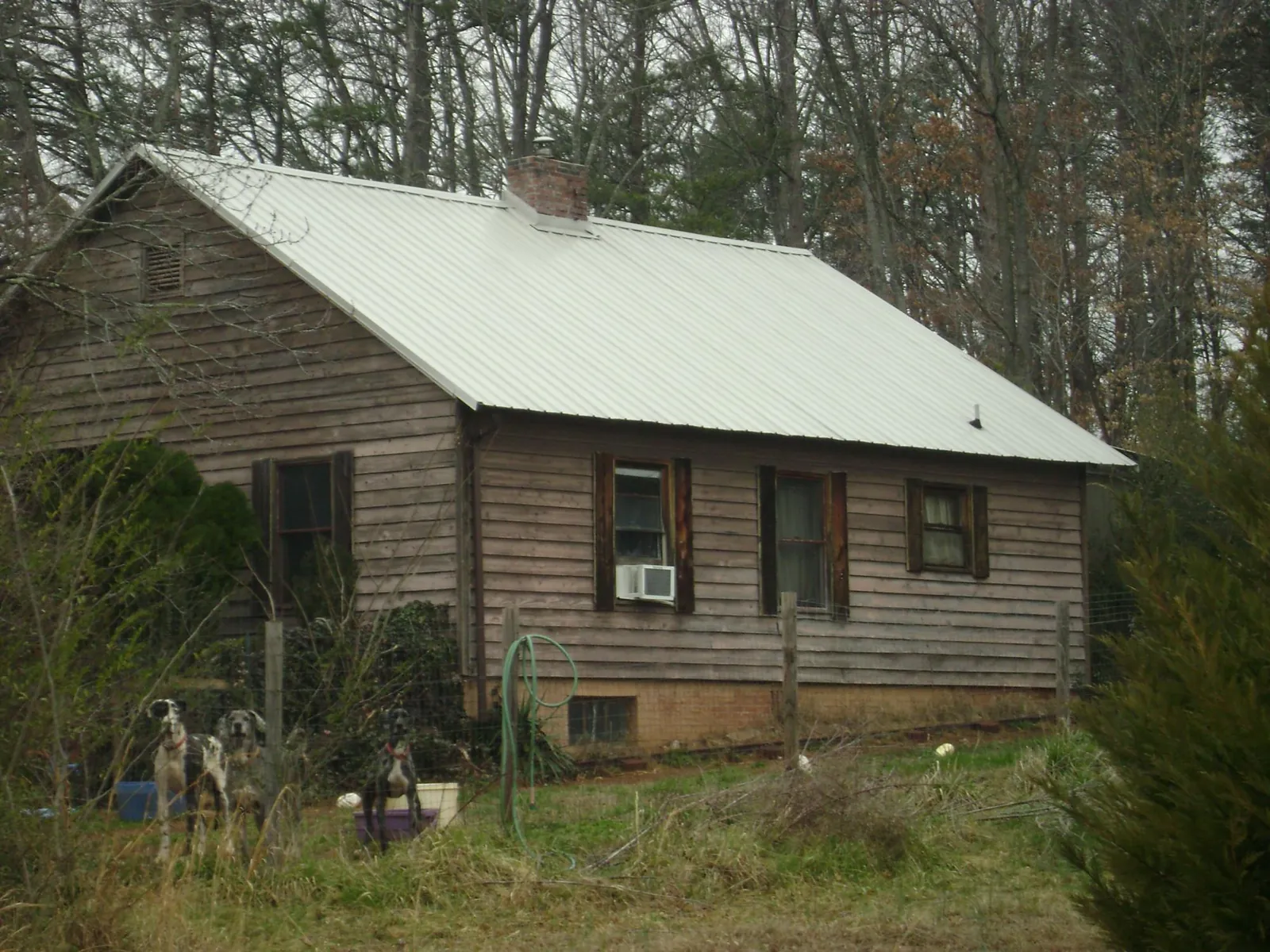 White metal roof on an old wood sided farmhouse, from a Metal Roof Installation job in Lapeer